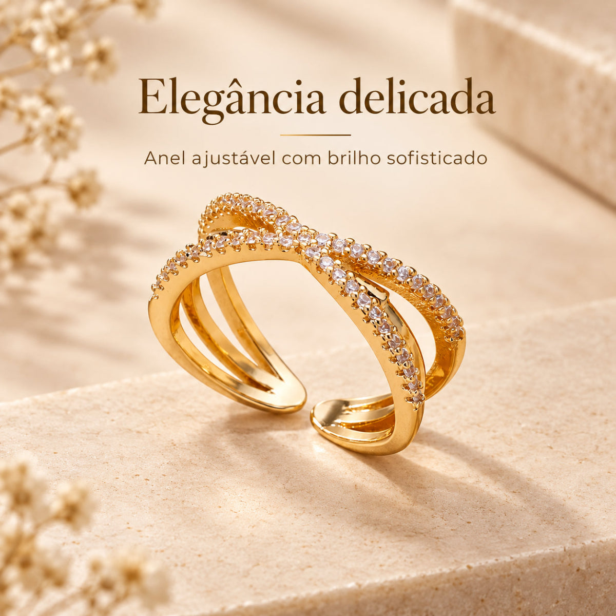 Anel GRACE dourado com design cruzado e detalhes brilhantes em cenário bege elegante
