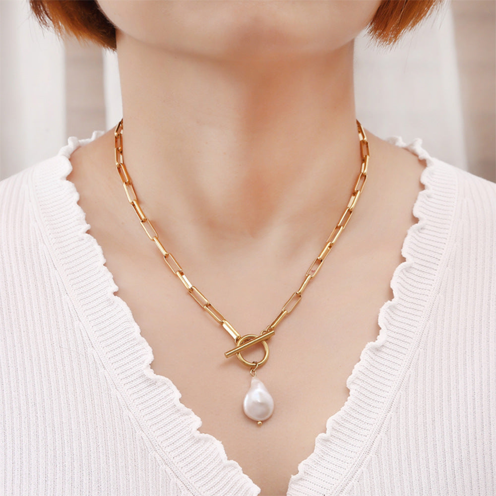 Colar IRIS dourado com pendente em gota usado ao pescoço