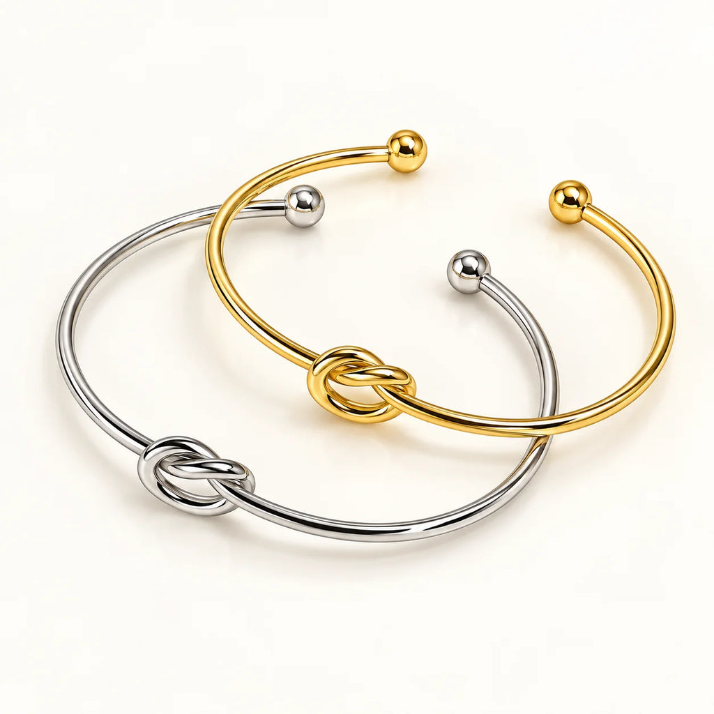 Pulseira NOA dourada e prateada com nó central em aço inoxidável, imagem principal do produto