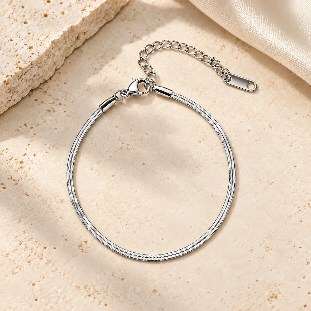 Pulseira NAYA prateada de corrente fina em aço inoxidável em composição editorial