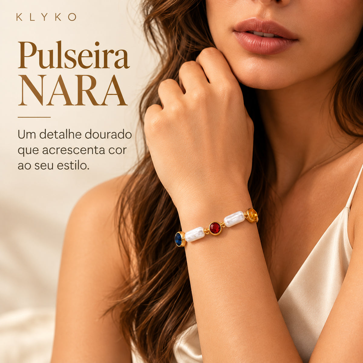 Pulseira NARA dourada usada no pulso, com elementos alongados e zircónias cúbicas coloridas.