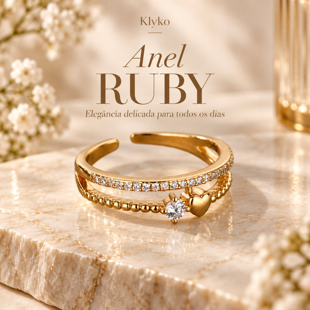 Anel RUBY com acabamento dourado, aro duplo e detalhe de coração em cenário bege