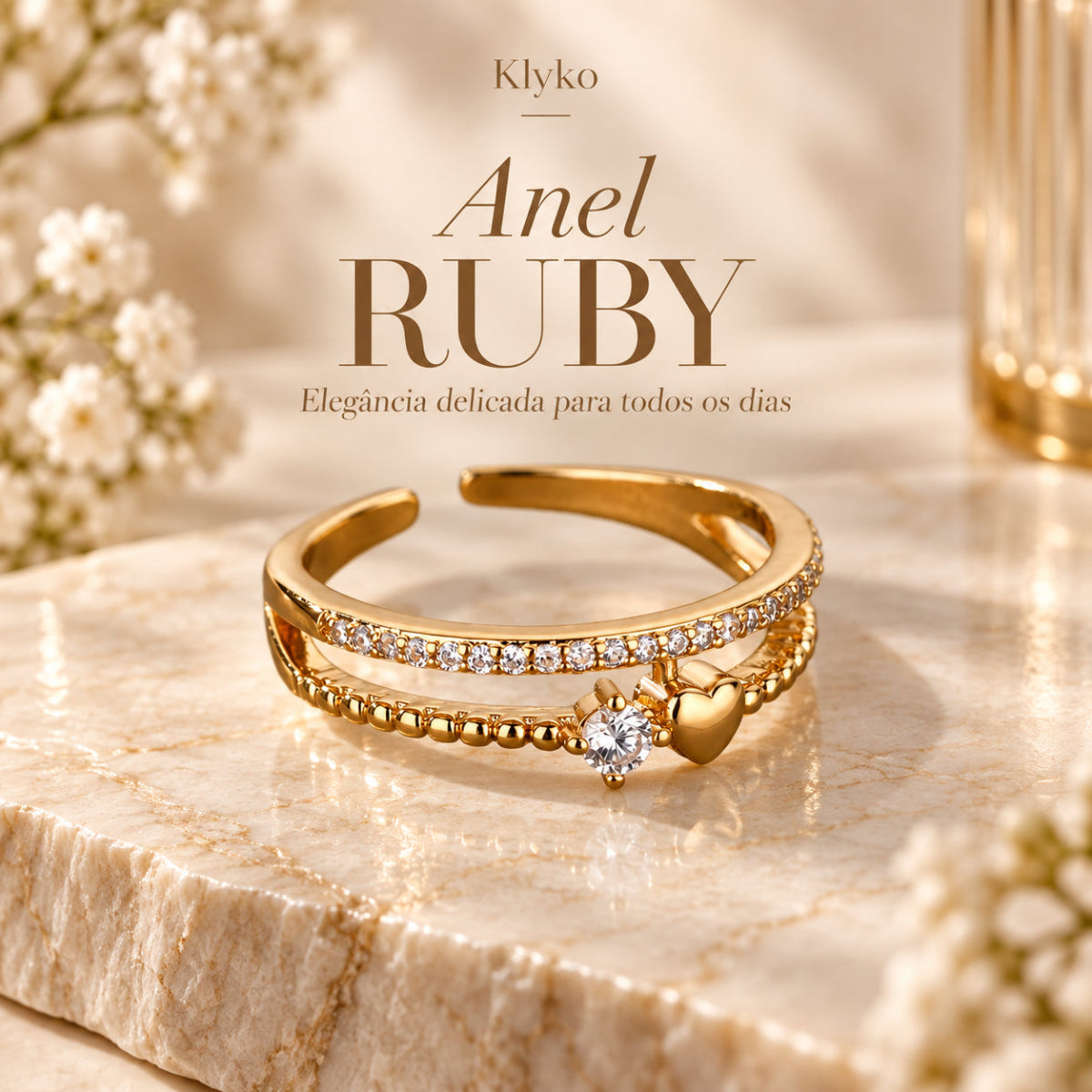 Anel RUBY com acabamento dourado, aro duplo e detalhe de coração em cenário bege