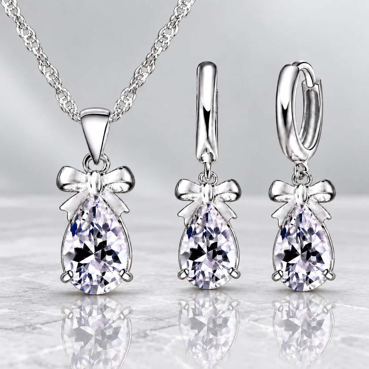 Conjunto LUMI com colar e brincos de zircónia cúbica em formato de gota e acabamento prateado