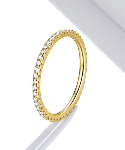 Anel DAISY dourado em aço inoxidável com linha contínua de zircónias cúbicas.