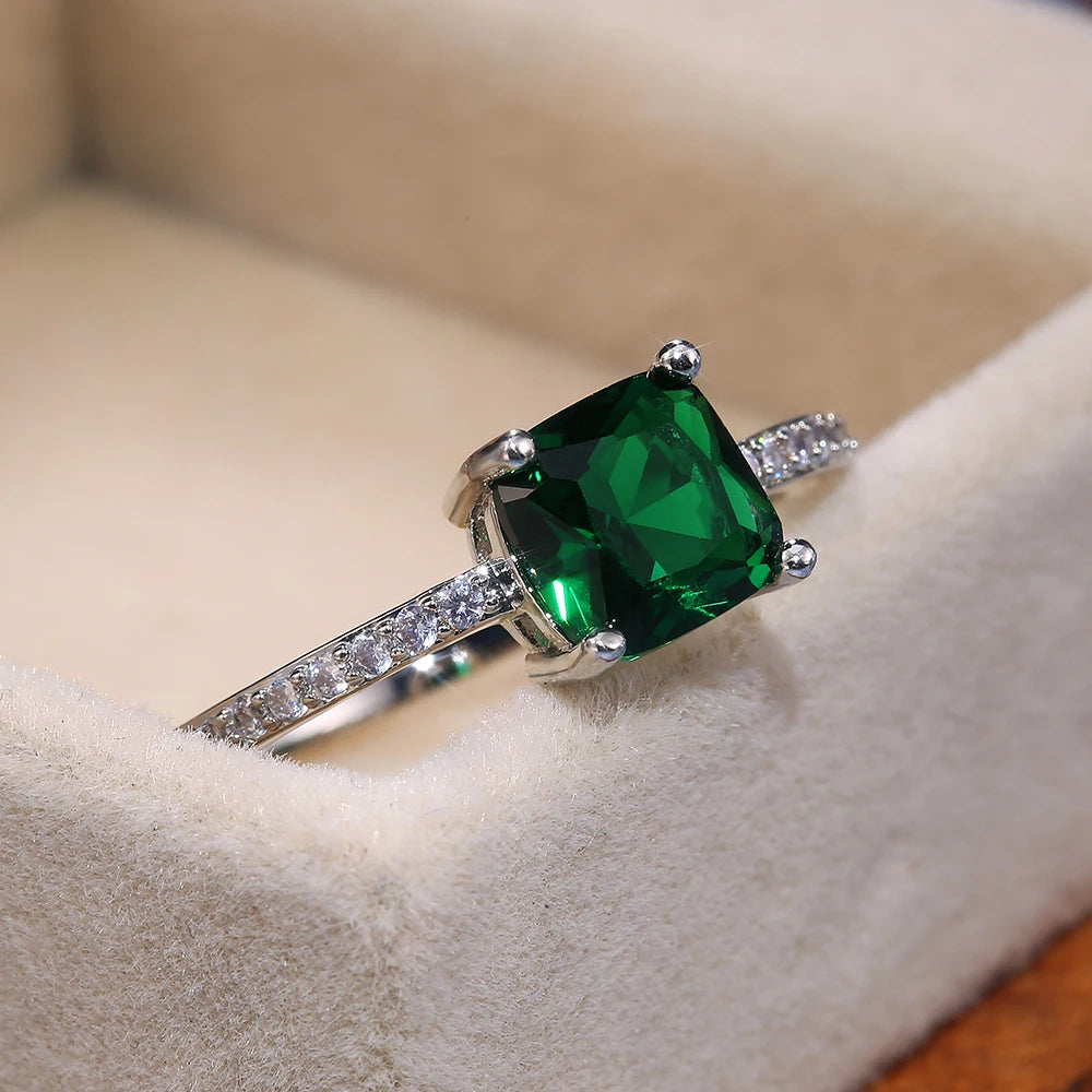Anel STELLA com pedra verde quadrada e detalhes laterais em zircónia cúbica.