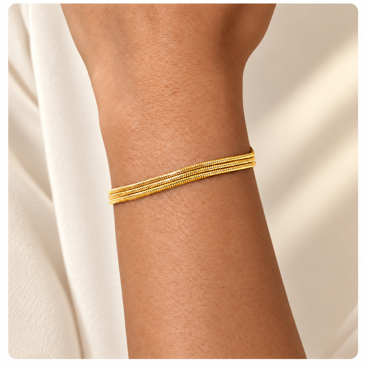 Pulseira LUMA dourada em aço inoxidável com várias correntes, apresentada em contexto lifestyle.