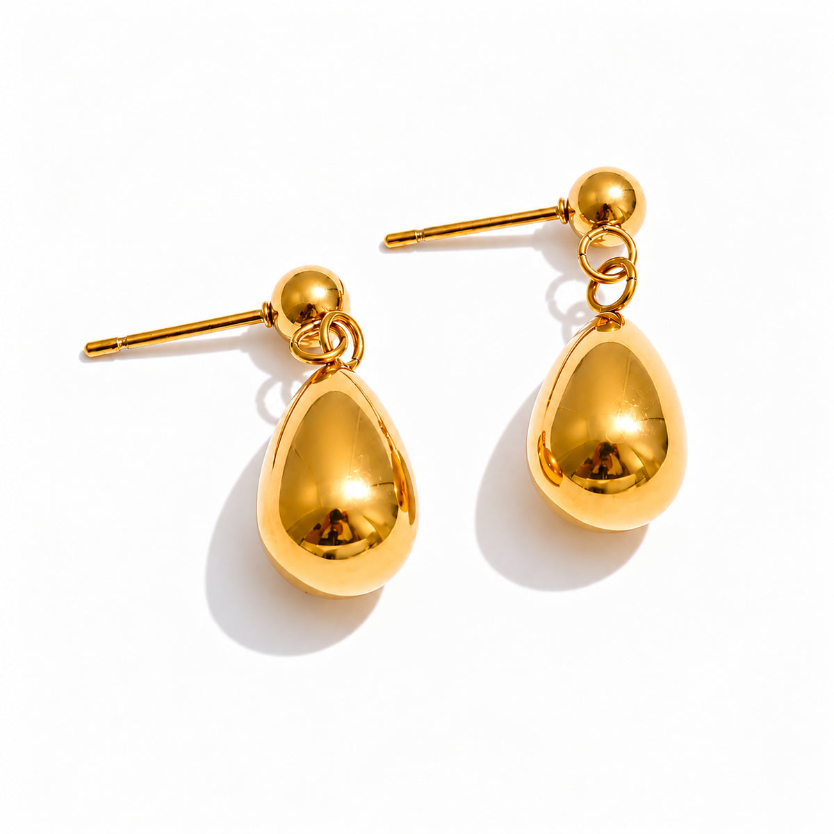 Brincos NOLA dourados e prateados em aço inoxidável com design pendente em forma de gota.