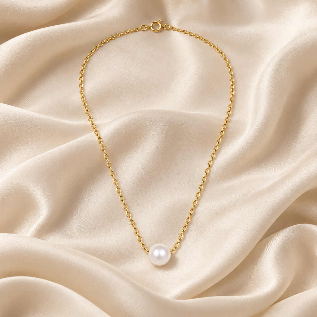 Detalhe da conta com efeito pérola e do pendente do Colar AURA dourado.