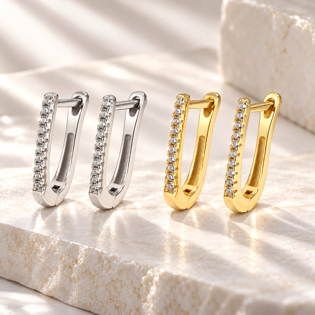 Brincos LUNA em U com zircónias em acabamentos prateado e dourado em cenário lifestyle