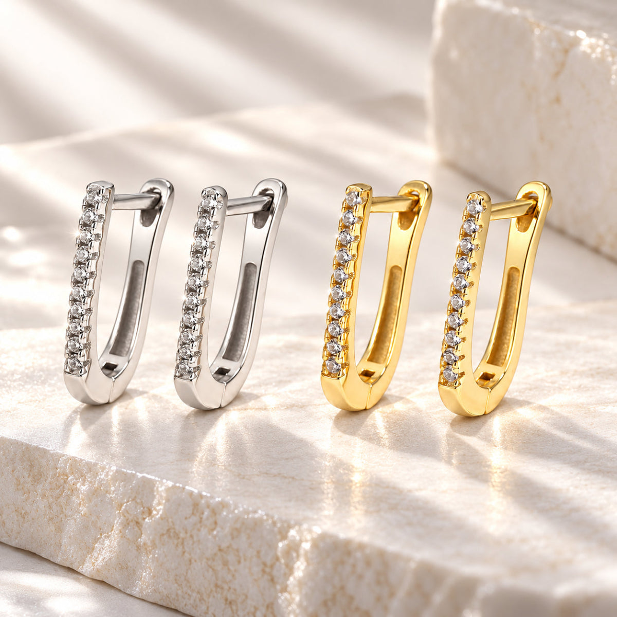 Brincos LUNA em U com zircónias em acabamentos prateado e dourado em cenário lifestyle