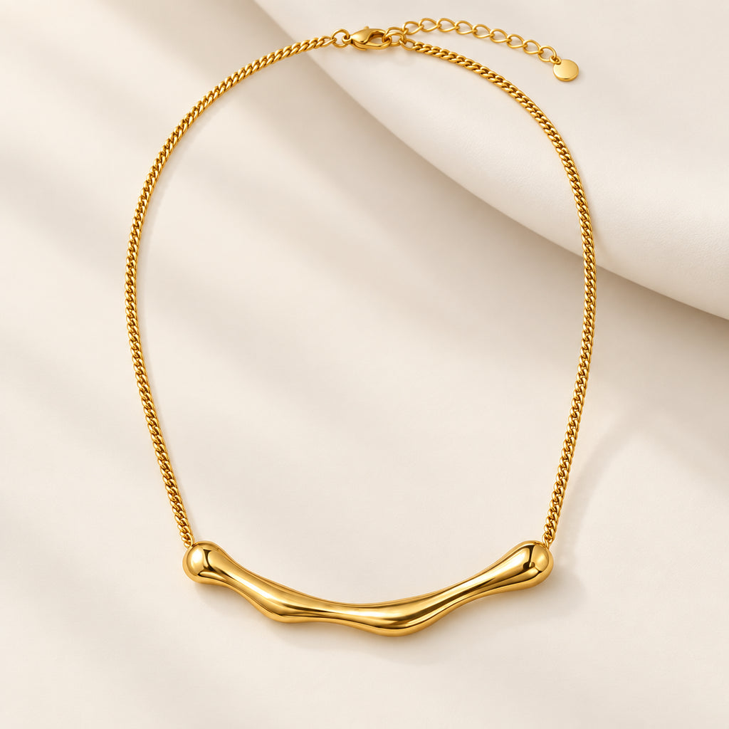 Colar MIRA dourado em aço inoxidável sobre fundo claro, com corrente tipo cobra