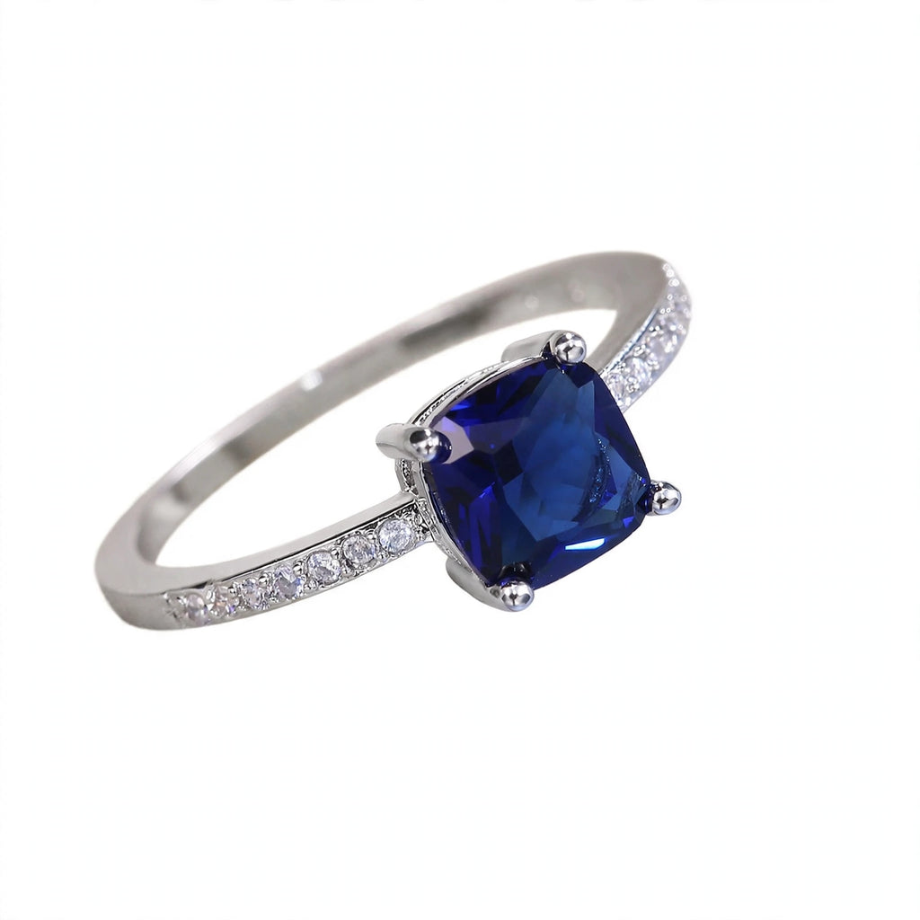 Anel STELLA com pedra azul safira quadrada e zircónias cúbicas laterais.