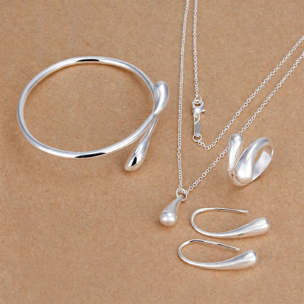 Conjunto NIVA com colar, brincos, pulseira e anel em fundo bege
